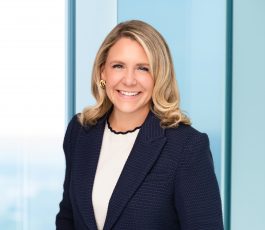 Becky Hudson headshot, blonde woman on blue corporate background
